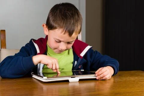 Little boy playing on tablet computer Stock Photos