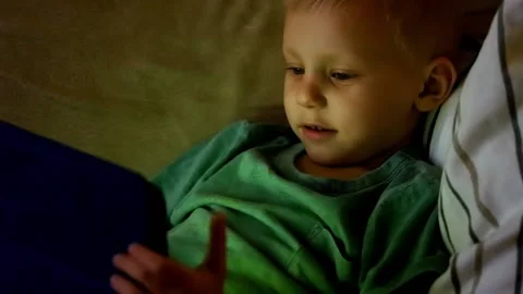 Little boy Playing with Tablet at night Stock Footage 90367439