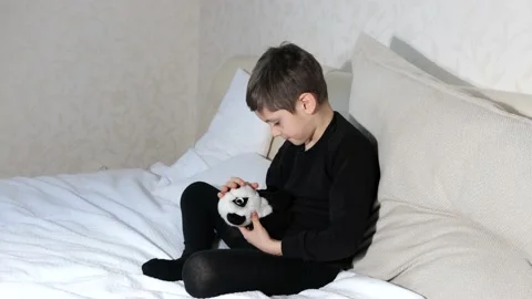 Little boy playing with a teddy bear in white bed Stock Footage 151971356