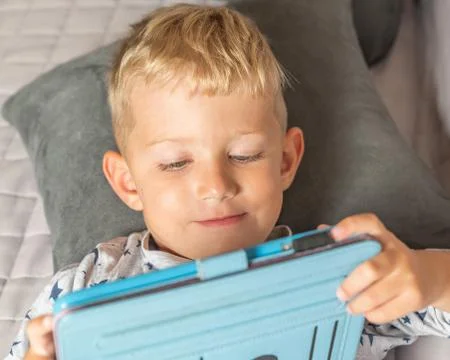 Little boy playing using digital tablet Stock Photos