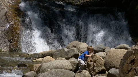 Little boy Playing on a Waterfall Stock Footage 129510487