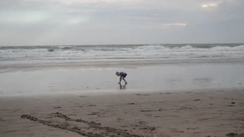 Little boy playing with waves on the beach, Bali, Indonesia Stock Footage 234121184