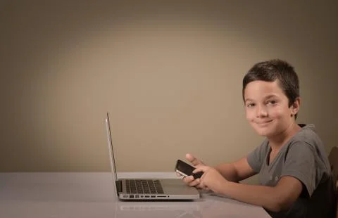 Little boy playing whith a computer and phone Stock-Fotos