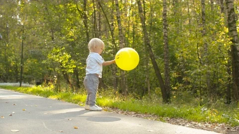 Little boy playing with yellow baloon Stock Footage 120596725