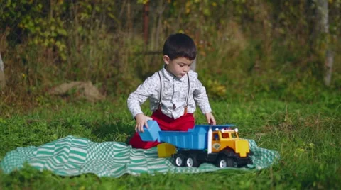 Little boy plays with cubes and machine in the garden Stock Footage 69060341