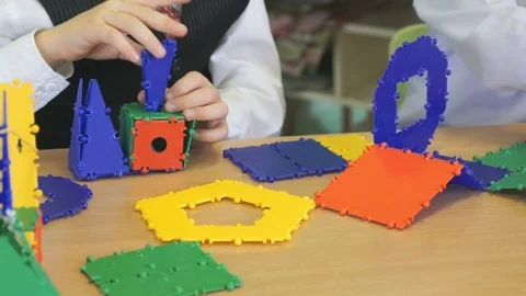 Little boy plays developing toy designer indoors Stock Footage 80354679