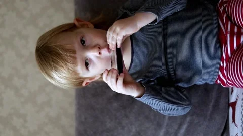 A little boy plays the harmonica. Little musician Stock Footage 224706361