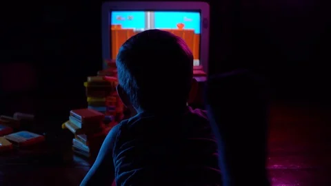 A little boy plays in a retro console, looking from behind his shoulders Stock Footage 126204773