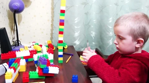 A little boy plays on the table designer, spoiled, lol. Video stock 48989972