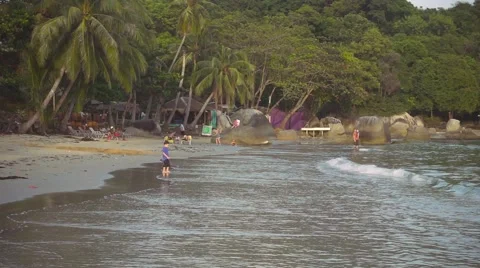 Little boy plays with waves on the beach at sunset. Slow motion Stock Footage 58792011