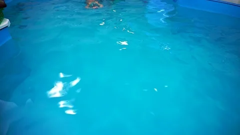 A little boy in the pool, the coach teaches him to swim. Video stock 101497738