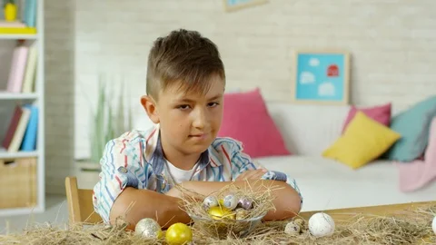 Little Boy Posing at Desk with Easter Eggs on Hay Stock Footage 106067074