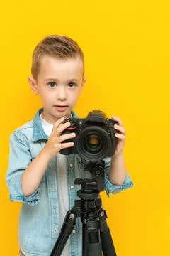 Little boy posing with digital camera on tripod Stock Photos