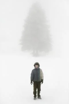 Little boy posing with hand up in a wintry snowy place Stock Photos