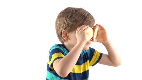 Little boy posing in studio on a white background with cut apple instead of eyes Stock Footage 124225018