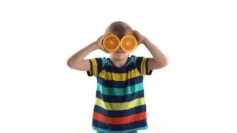 Little boy posing in studio on a white background with cut orange instead of Stock Footage 124458401