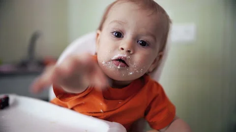 Little boy practices eating in the kitchen extends a hand  21  - Color corrected Stock-Footage 55109707