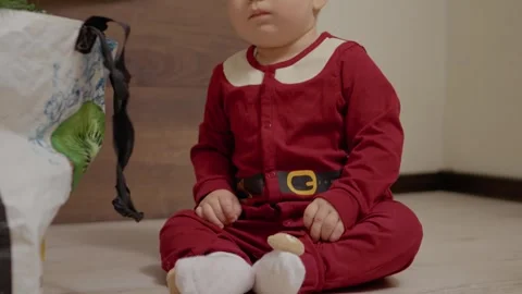 Little boy prepares for Christmas by sorting decorations in festive attire Stock Footage 314770540