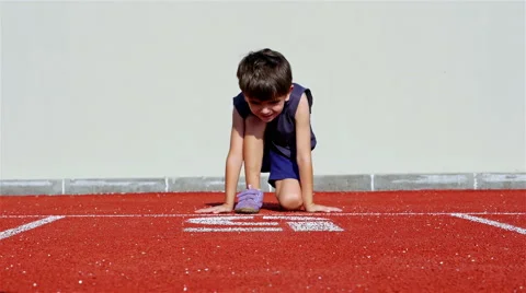 Little boy preparing to run in an athletic track Video stock 66293437