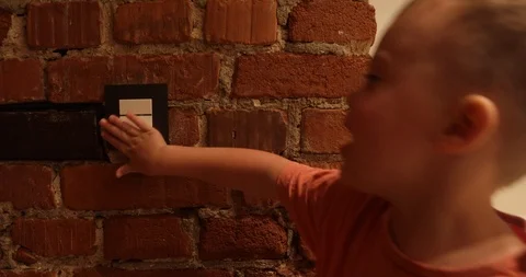 Little boy pressure the light switch and turns off the light Stock Footage 115823338