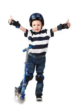 Little boy in protection helmet and in the knee and arm ruffles riding his... Stock Photos