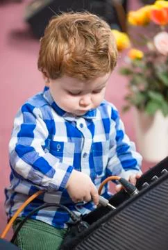 Little boy putting a cable into a speaker Stock Photos