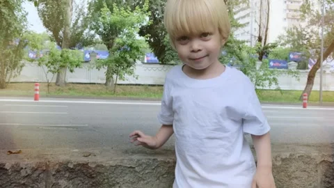 A little boy raises his hands up against the backdrop of the city. Stock Footage 270140168