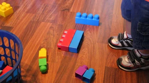 Little boy reaching down to pick up blocks Stock Footage 44445696