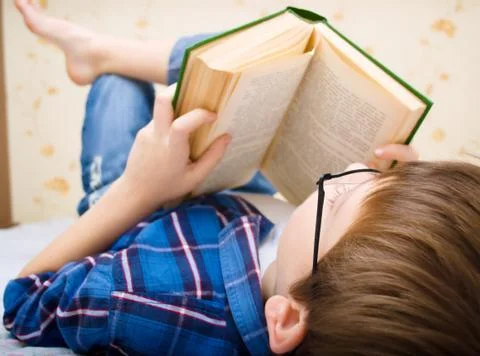 Little boy is reading a book Stock Photos