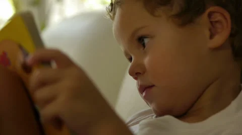 Little boy reading a book on a sofa Stock Footage 35909467