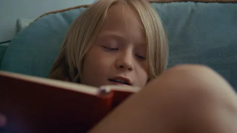 Little Boy Reading Book by Window at Home 库存影片 344729412