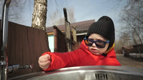 A little boy in a red jacket walks in the zoo Stock Footage 271636724
