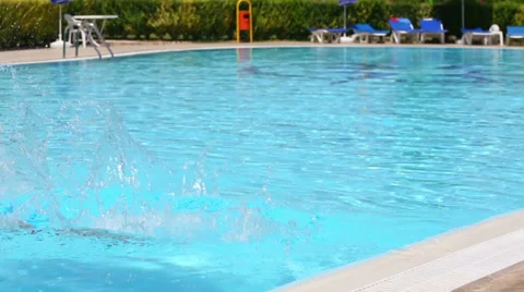 Little boy in red trunks dive into the pool near the hotel 動画素材 35234239