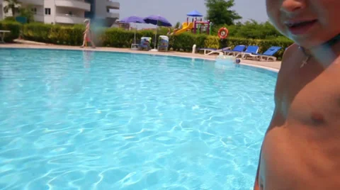 Little boy in red trunks dive into water from edge of the pool 動画素材 35234952