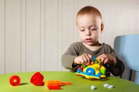 Little boy repairs auto Fotos Stock