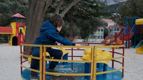 A little boy is riding a carousel in the playground Stock Footage 74732101
