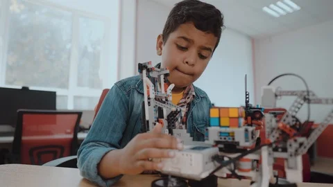 Little boy in robotics school makes robot. Afro-american young schoolboy Stock Footage 112876517