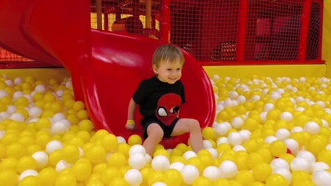 A little boy is rolling down a slide slow motion Stock Footage 282621706