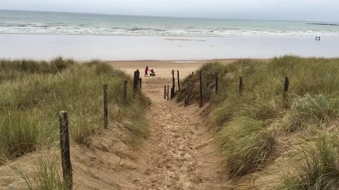 Little boy running down a sand dune to the sea Vídeo Stock 76247633