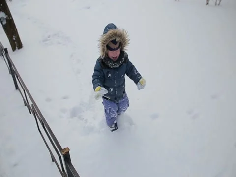 Little boy running through the snow slow motion Stock Footage 73356176
