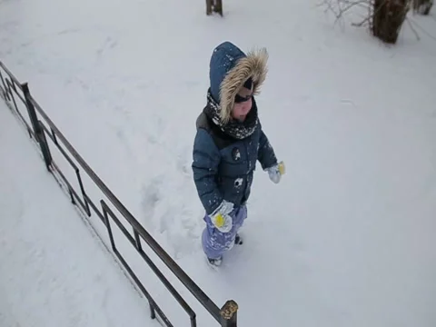 Little boy running through the snow slow motion Stock Footage 73356199
