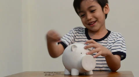 Little boy saving money in to piggy bank Stockbeeldmateriaal 43046653