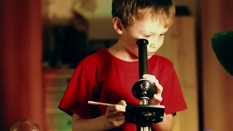 Little boy in science lab study samples under microscope. Schoolboy looking Video stock 128581815
