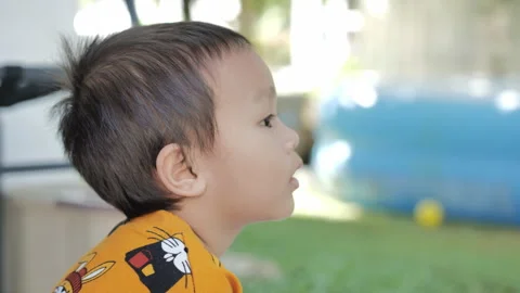 A little boy is silent and brooding in his yard Stock Footage 240491928