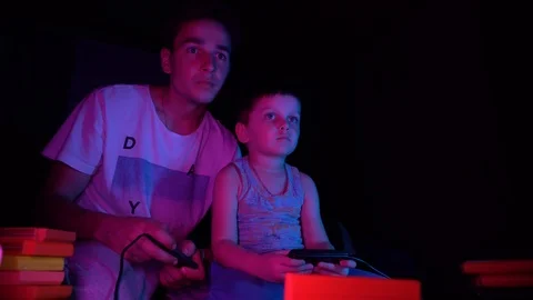 A little boy sits in front of the TV and plays in a retro console Stock Footage 126204530