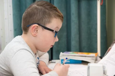 Little boy sits at a table Stock Photos