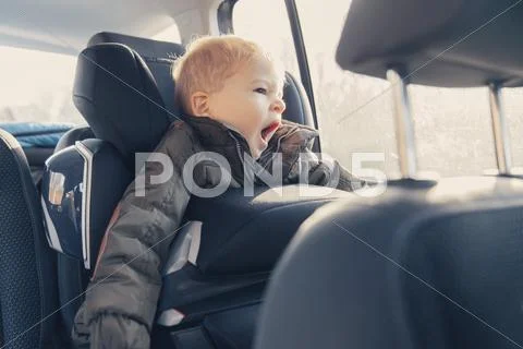 Little Boy Sitting In Back-Seat Car Seat, Yawning