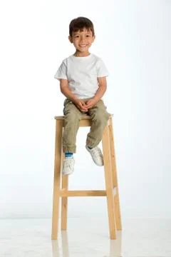 Little boy sitting on a high stool 写真素材