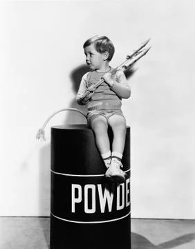 Little boy sitting on powder keg Stock Photos