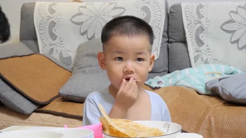 Little boy sitting at the table and eating Stock Footage 157218221